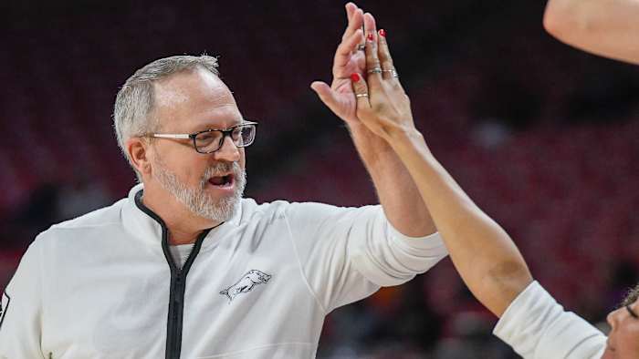 Razorbacks coach Mike Neighbors high-fives an assistant during 71-66 win over Texas Tech on Friday night.